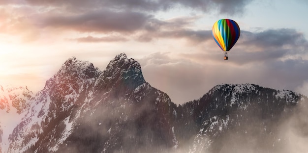 Dramatyczny krajobraz górski pokryty chmurami i lot balonem na ogrzane powietrze