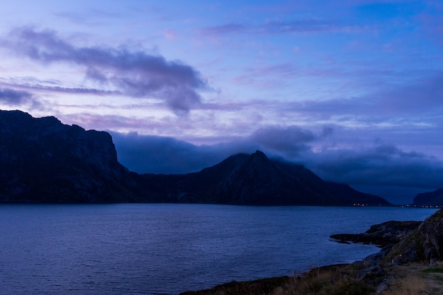 Dramatyczny zachód słońca krajobraz z morzem i górami na Lofotach w Norwegii