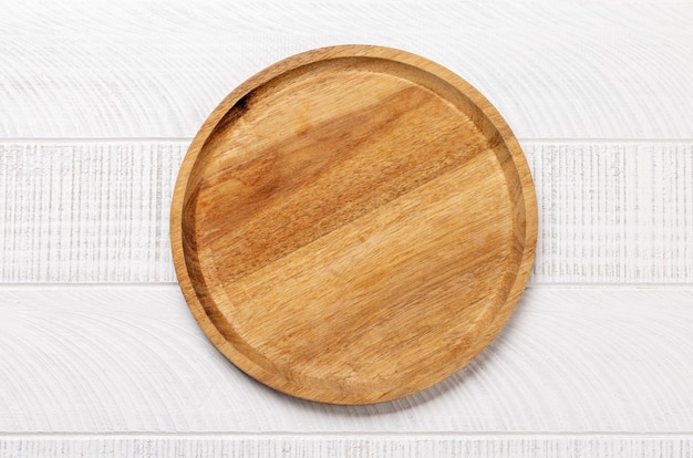 Drewniana deska do krojenia na białym stole w kuchni