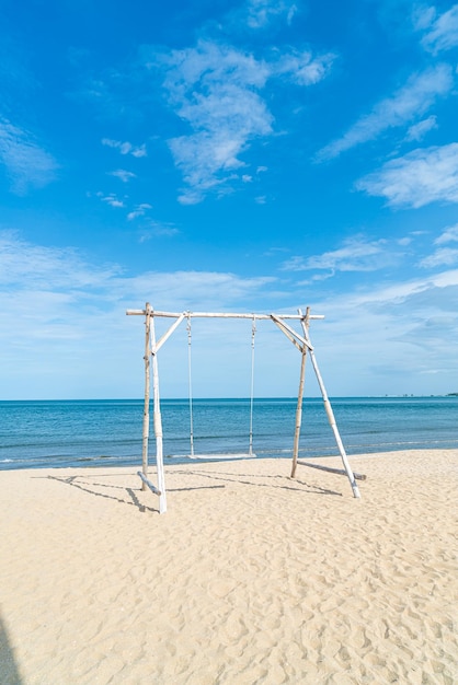 drewniana huśtawka na plaży z tłem plaży morskiej