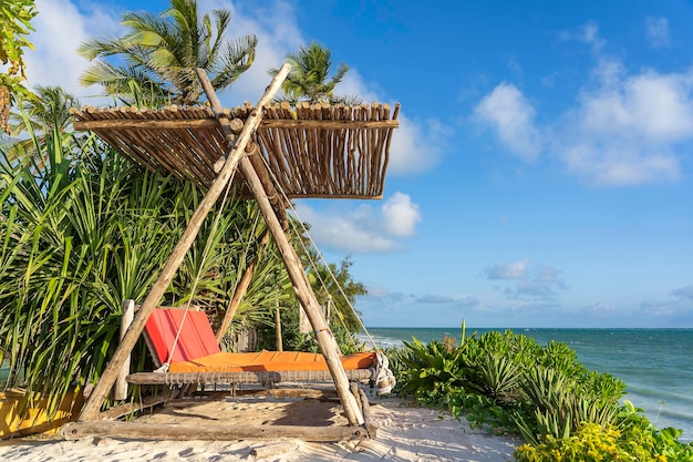 Drewniana huśtawka pod baldachimem na tropikalnej plaży w pobliżu morskiej wyspy Zanzibar Tanzania Afryka Wschodnia