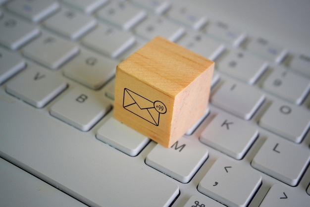 Zdjęcie drewniana kostka z nową ikoną powiadomienia e-mail na górze klawiatury koncepcja komunikacji i technologii