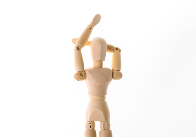 Drewniana lalka rozciąga ramiona na białym tle. Zdrowy styl życia, koncepcja sportu