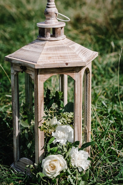 Drewniana latarnia z kwiatami i zielenią Stylizowana na vintage Piękny świecznik na łonie natury Wystrój ślubny na lato Droga na drogę Dekoracja ślubna w aranżacji w stylu rustykalnym