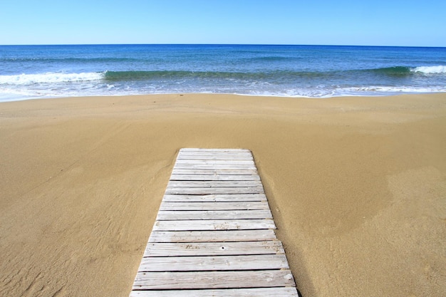 Drewniana podłoga na złotej piaskowatej plaży