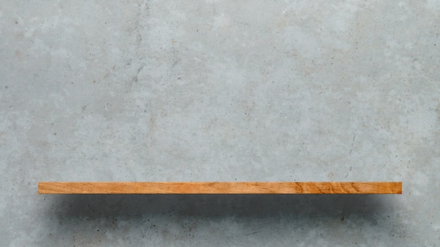 Drewniana półka nad białym betonowej ściany tłem