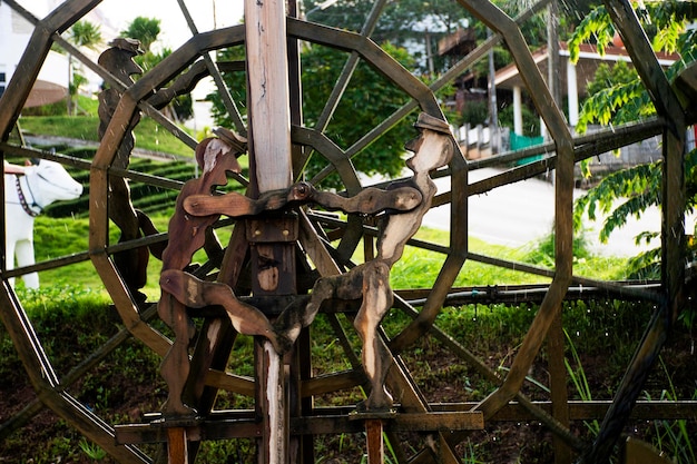 Drewniana prasa do belowania lub drewniane koła wodne w kanale potoku do oczyszczania wody na stawie basenowym w odkrytym parku ogrodowym w świątyni Wat Huay Pla Kang w czasie zachodu słońca w Chiang Rai Tajlandia