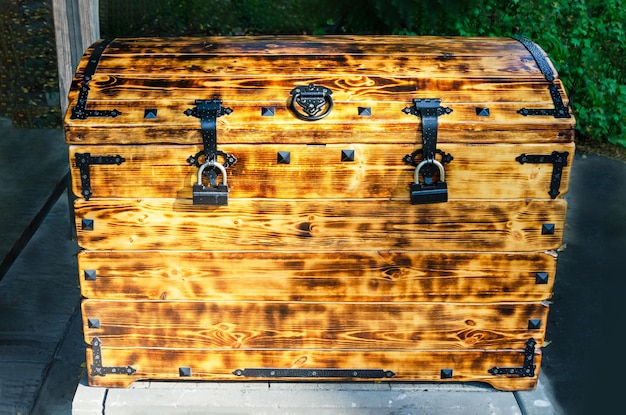 Drewniana skrzynia w pudełku zbliżeniowym w stylu retro z żelaznymi zamkami połączonymi teksturowanymi spalonymi deskami