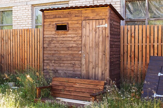 Drewniana toaleta na zewnątrz w zbliżeniu na podwórku