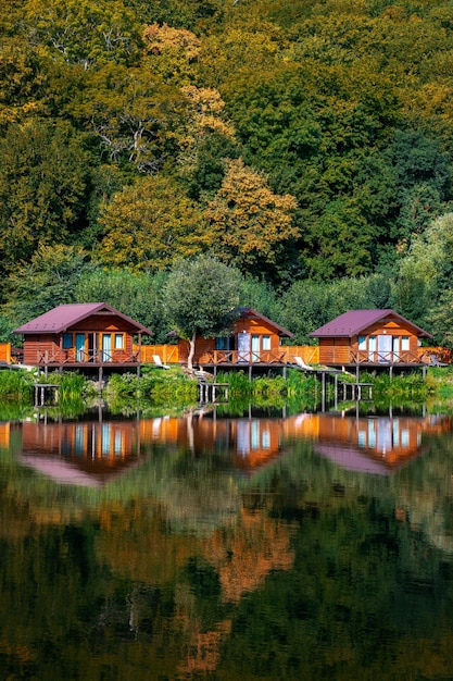 Drewniane domki nad wodą w pobliżu lasu do połowu karpi Miejsce wypoczynku na łonie natury Jesienny karp f