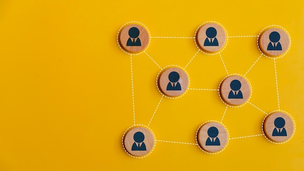Drewniane klocki połączone ze sobą na żółtym tle Sieć pracy zespołowej i koncepcja społeczności