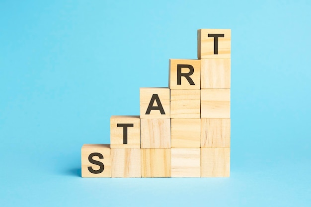 Drewniane klocki ze słowem START zacznij nową karierę lub nowy biznes, aby odnieść sukces lub nastawienie koncepcja trend pomysł strategia cel marketingowy online i plan docelowy