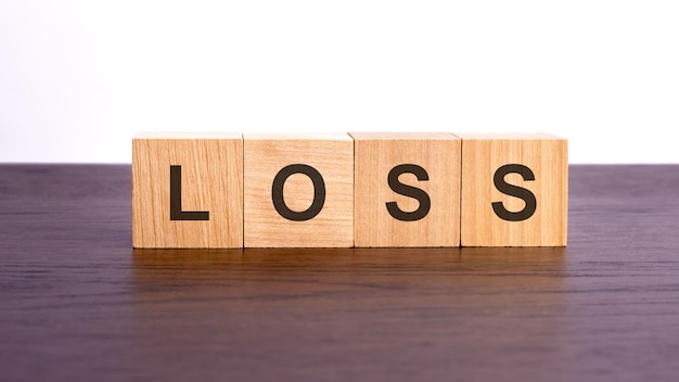 Zdjęcie drewniane kostki z tekstem strata na drewnianym stole koncepcja biznesowa strat finansowych