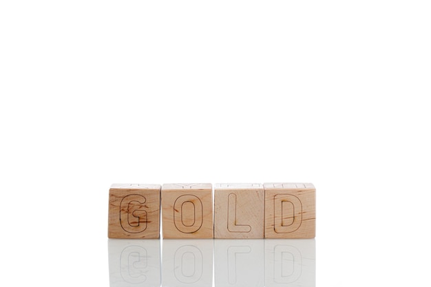 Drewniane kostki z złotymi literami na białym tle