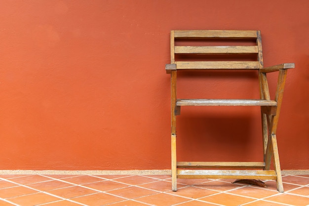 Zdjęcie drewniane krzesła na terakotowych podłogach i pomarańczowych tynkach na ścianach