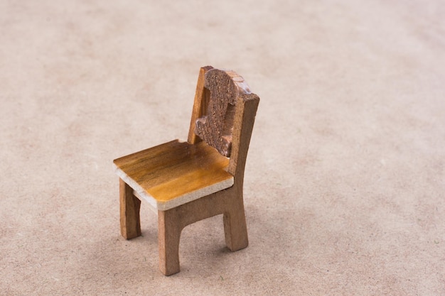 Drewniane krzesło do zabawy w kolorze brązowym na kolorowym tle