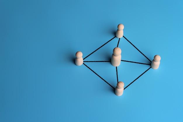 Zdjęcie drewniane lalki połączone liniami z kopią przestrzeni przywództwo wspiera koncepcję sieci pracy zespołowej