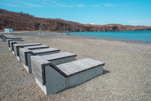 Zdjęcie drewniane leżaki na plaży ahlestisheva na wyspie russky w władywostoku