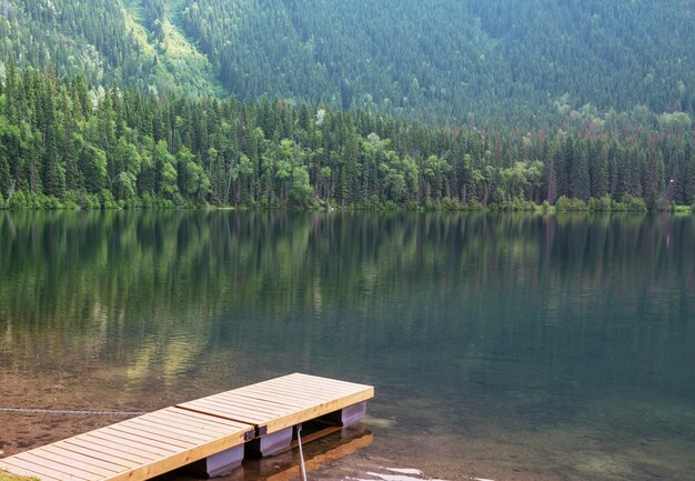 Drewniane molo w spokojnym jeziorze w górach