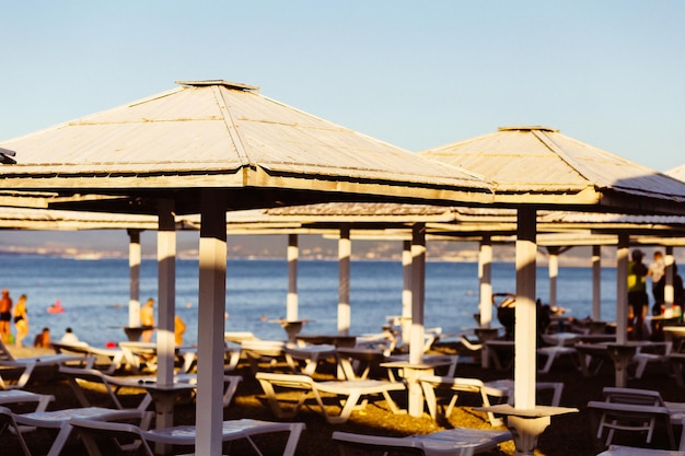 Zdjęcie drewniane parasole plażowe na rozmytym tle leżaków i morza