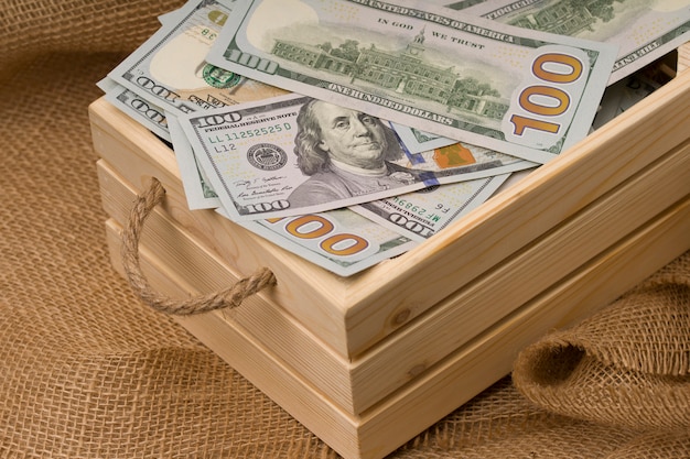 Zdjęcie drewniane pudełko z pieniędzmi. tło worze. koncepcja ekologii i pieniędzy