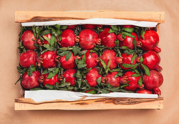 Drewniane pudełko z widokiem czerwonych granatów z góry dostawa owoców