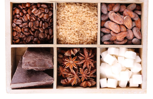 Zdjęcie drewniane pudełko z zestawem ziaren kawy i kakao kostek cukru z ciemnej czekolady, cynamonu i anyżu na białym tle