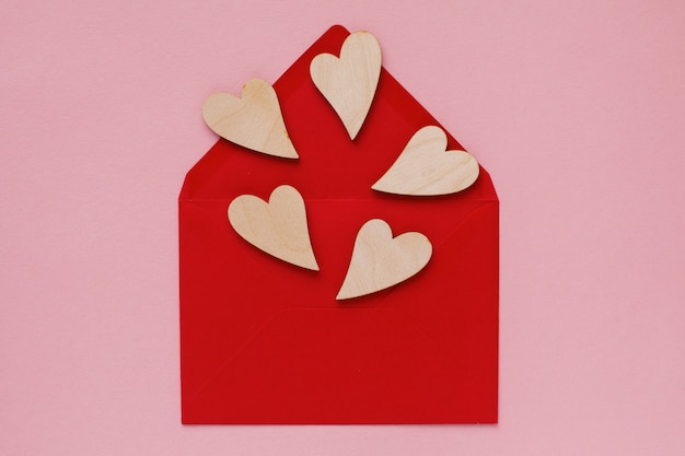 Drewniane serca w czerwonej kopercie z papieru