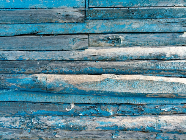 Drewniane tło z peelingiem niebieską farbą.