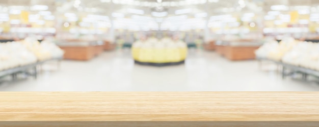 Drewniany blat z supermarketem sklep spożywczy rozmazane tło z wyświetlaczem światła bokeh