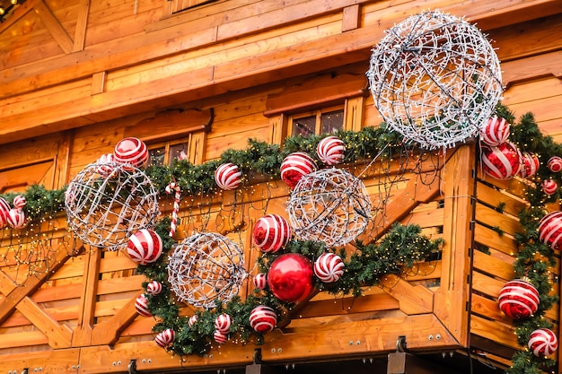 Drewniany Budynek Restauracji W Stylu Vintage Ozdobiony Sztuczną Jodłą Z Girlandą I Wieloma Czerwonymi I Białymi Bombkami W Zimowy Dzień, Bez śniegu.