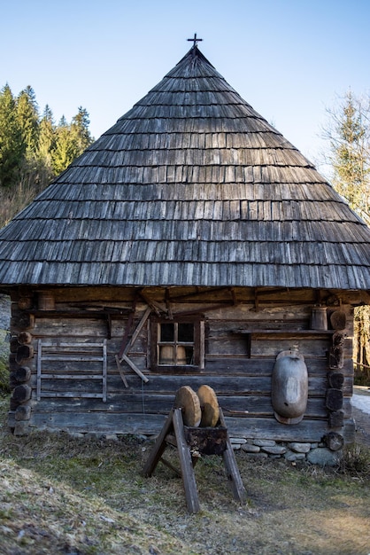 Drewniany dom kryty strzechą i drewnianym dachem.