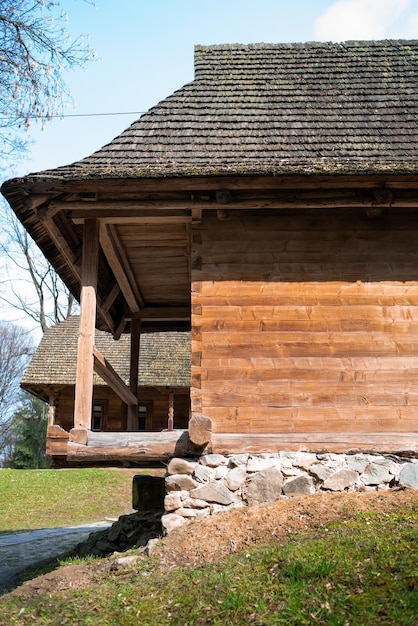 Drewniany dom kryty strzechą i dużym dachem krytym strzechą.