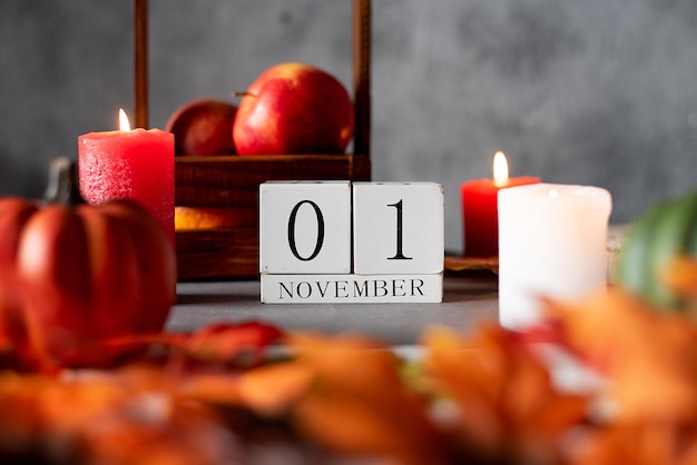 Drewniany kalendarz 1 listopada dekoracje jesienne jabłka świece i dynie