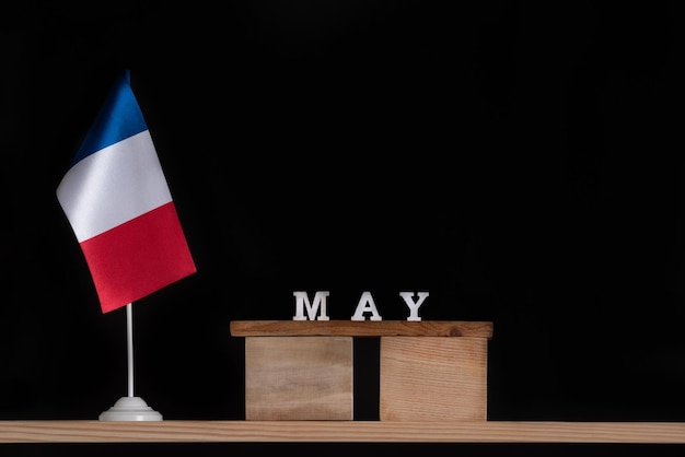 Drewniany kalendarz maja z francuską flagą na czarnym tle Święta Francji w maju