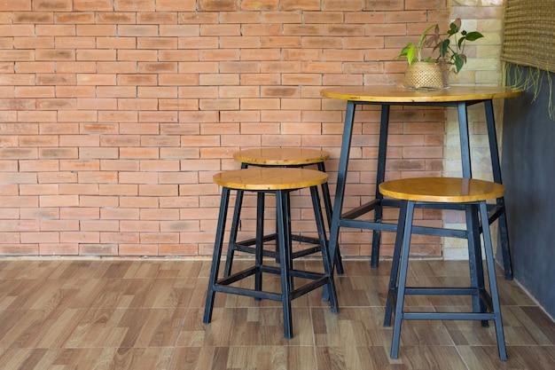Zdjęcie drewniany krzesło i stół na ściana z cegieł
