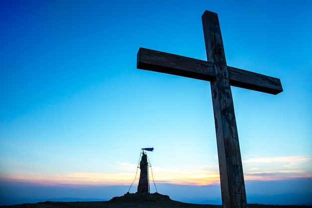 Zdjęcie drewniany krzyż na tle wschodu słońca w górach