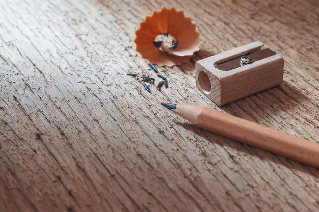Drewniany ołówek z ostrzenie goleniami na starym drewnianym tekstury tle