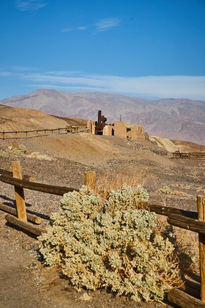 Drewniany płot w Dolinie Śmierci i pustynny krzew przy starych konstrukcjach