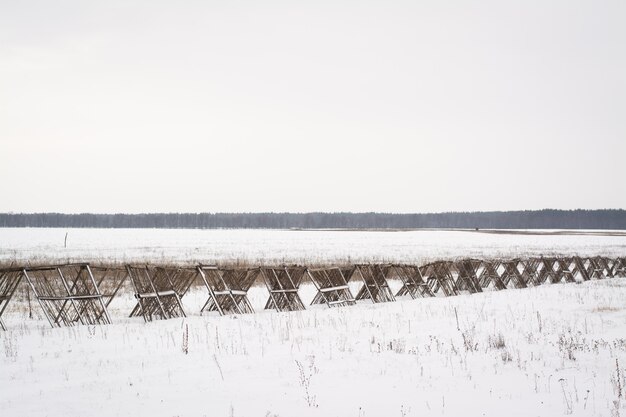 Zdjęcie drewniany płot w polu do ochrony drogi przed zamiecią w zimie