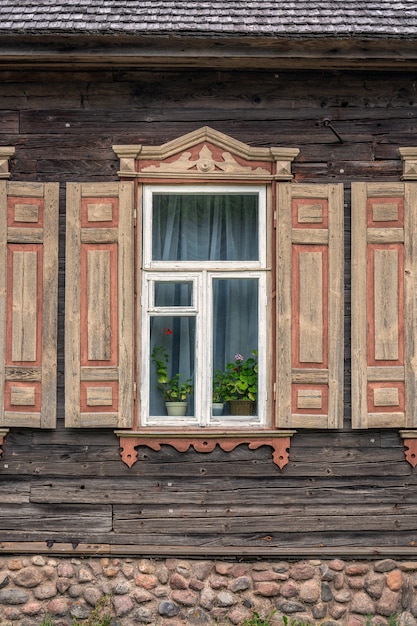 Drewniany stary okno w rzeźbiącej drewnianej architekturze