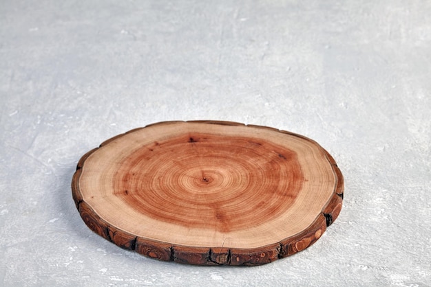 Drewniany stojak na danie na betonowym tle Wycięcie pnia drzewa w celu zaprezentowania prezentacji produktu