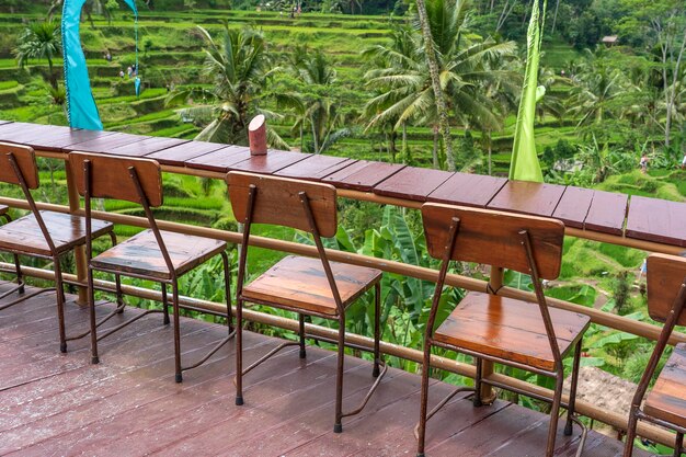 Drewniany stół i krzesła w pustej tropikalnej kawiarni obok tarasów ryżowych na wyspie Bali, Indonezja