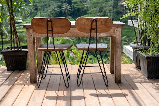 Zdjęcie drewniany stół i krzesła w pustej tropikalnej kawiarni obok tarasów ryżowych na wyspie bali, indonezja