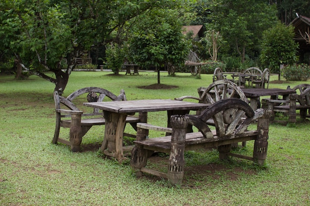 Drewniany stół ustawiony w zielonym ogrodzie