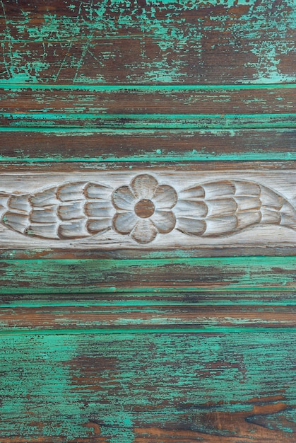 Drewniany stół z wyrzeźbionym w środku kwiatkiem.