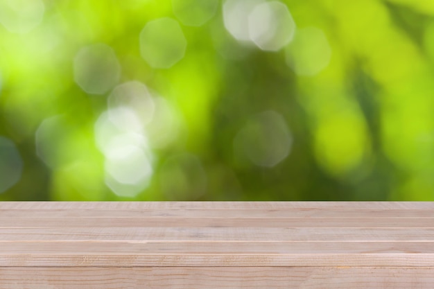 Zdjęcie drewniany stołowy wierzchołek na bokeh zieleni tle