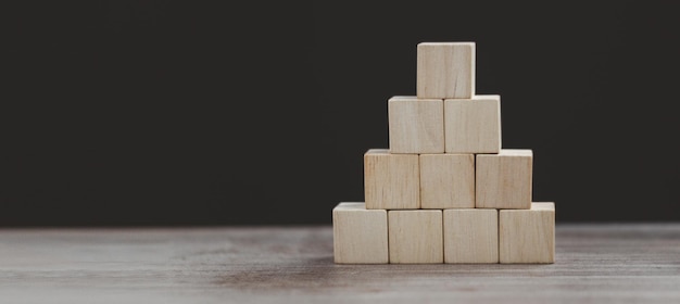 Drewniany sześcian ułóż w koncepcji biznesowej w kształcie piramidy