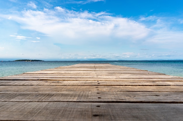 Drewniany taras w stylu vintage na plaży z niebieskim tłem morza, oceanu, nieba