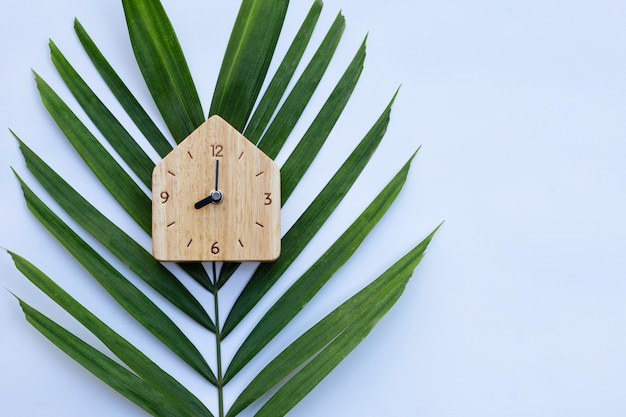 Drewniany zegar na liściach palmowych